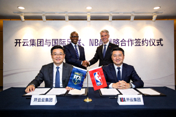开云集团与国际足联、NBA等顶级赛事IP战略合作签约仪式 - 签约桌上摆放着双方旗帜与合同，企业代表与赛事官员握手合影